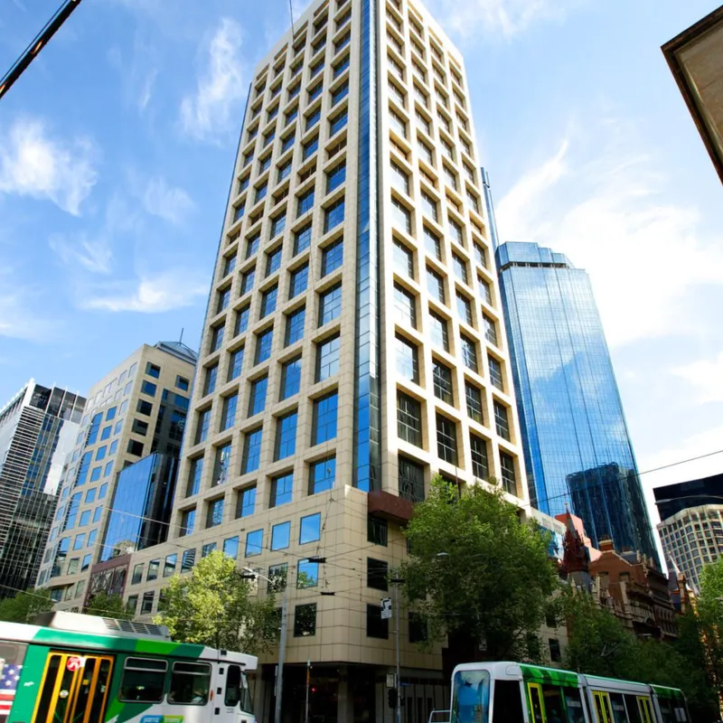 Gradient Information Systems' office building in Melbourne, a modern high-rise with a beige and glass facade featuring a grid-like window design.